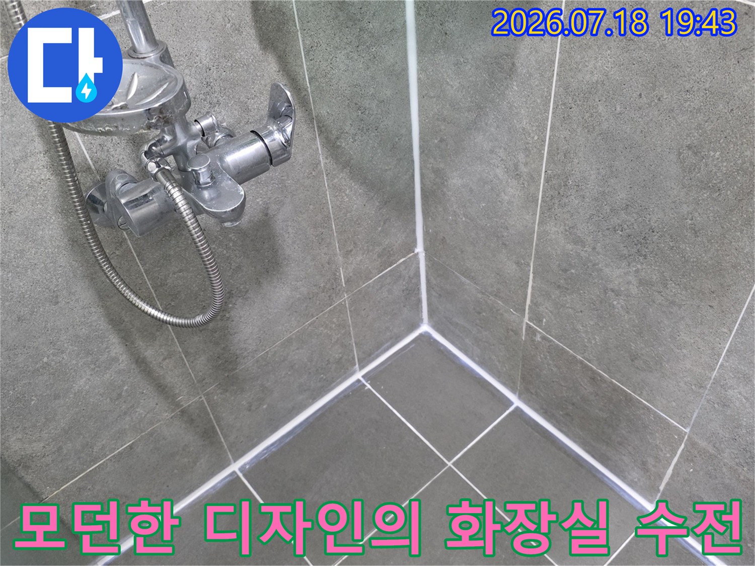회색 타일 배경에 설치된 금속 재질 샤워기 및 수도꼭지 사진