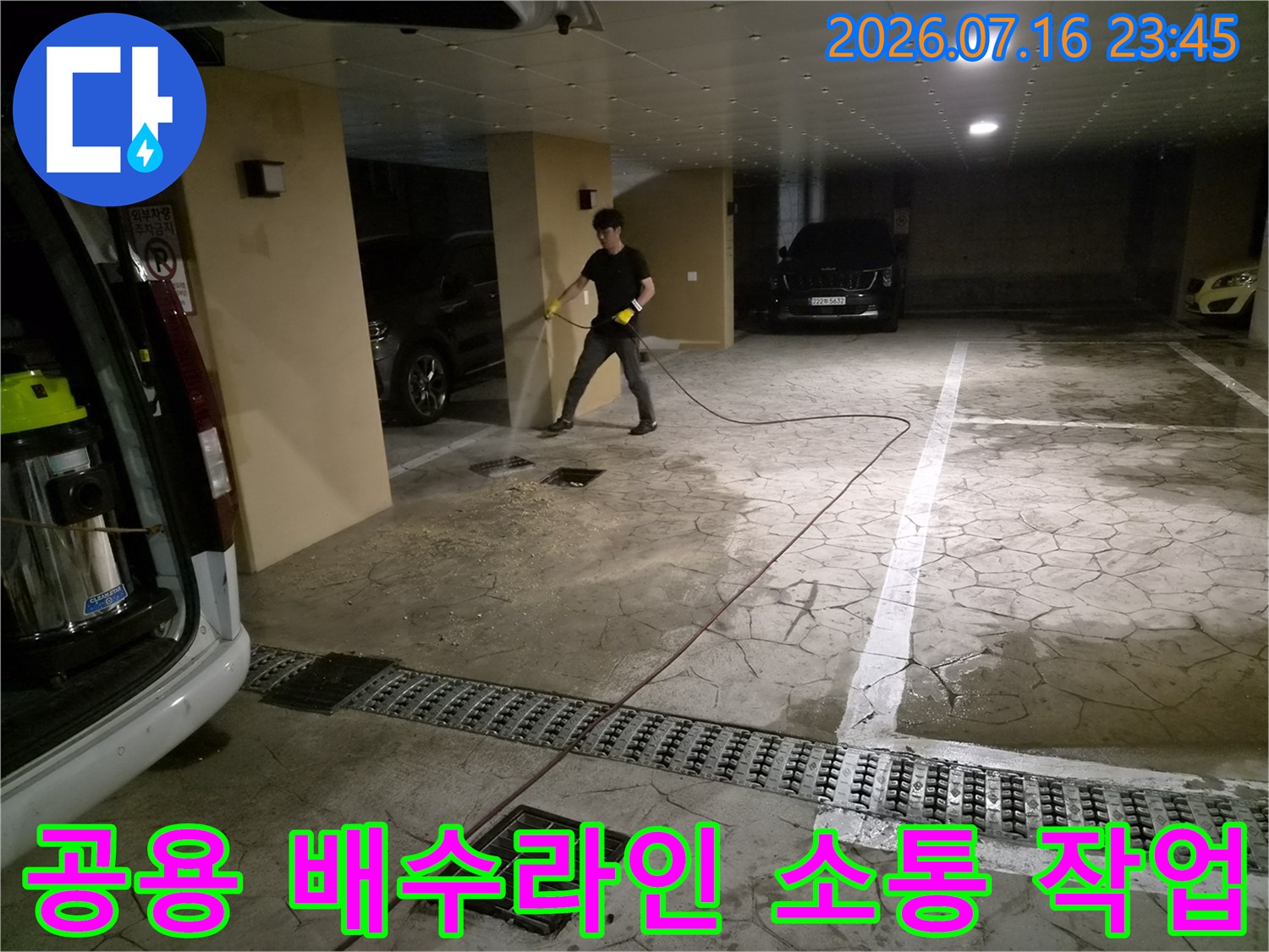 고압 세척 장비를 통해 지하 주차장 공용 배관 내 이물질을 씻어내며 막힘을 해결하는 모습