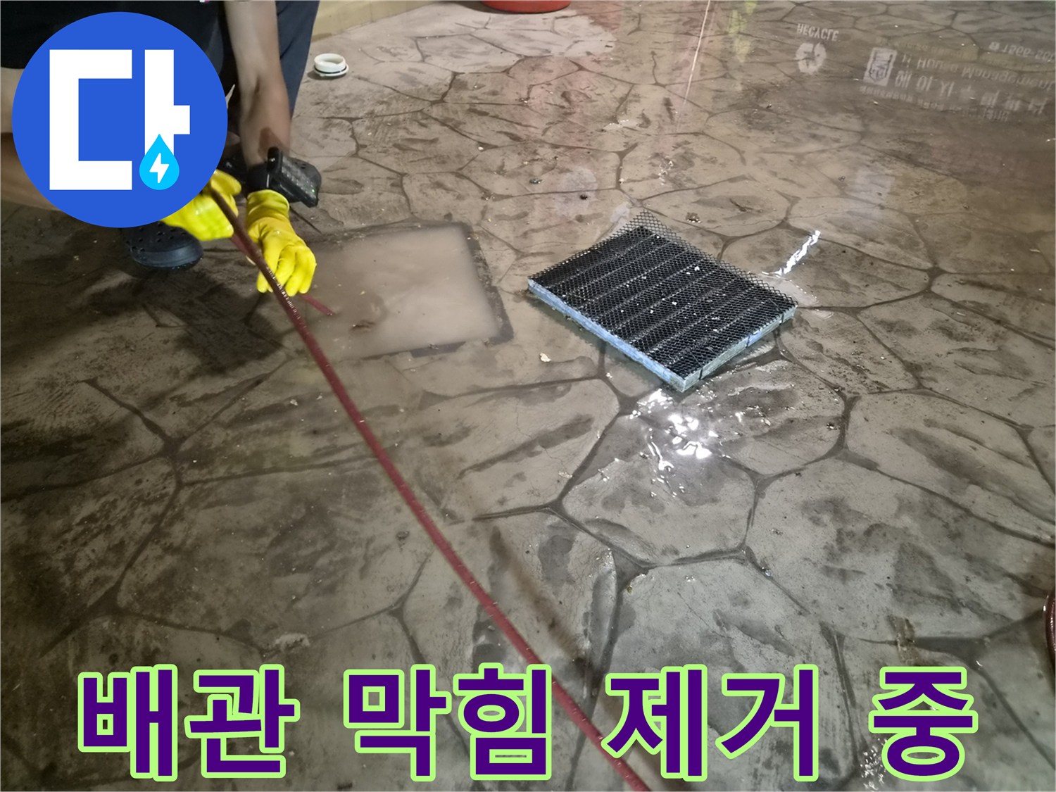 고여 있는 물을 빼내기 위해 배수구에 장비를 투입하는 모습