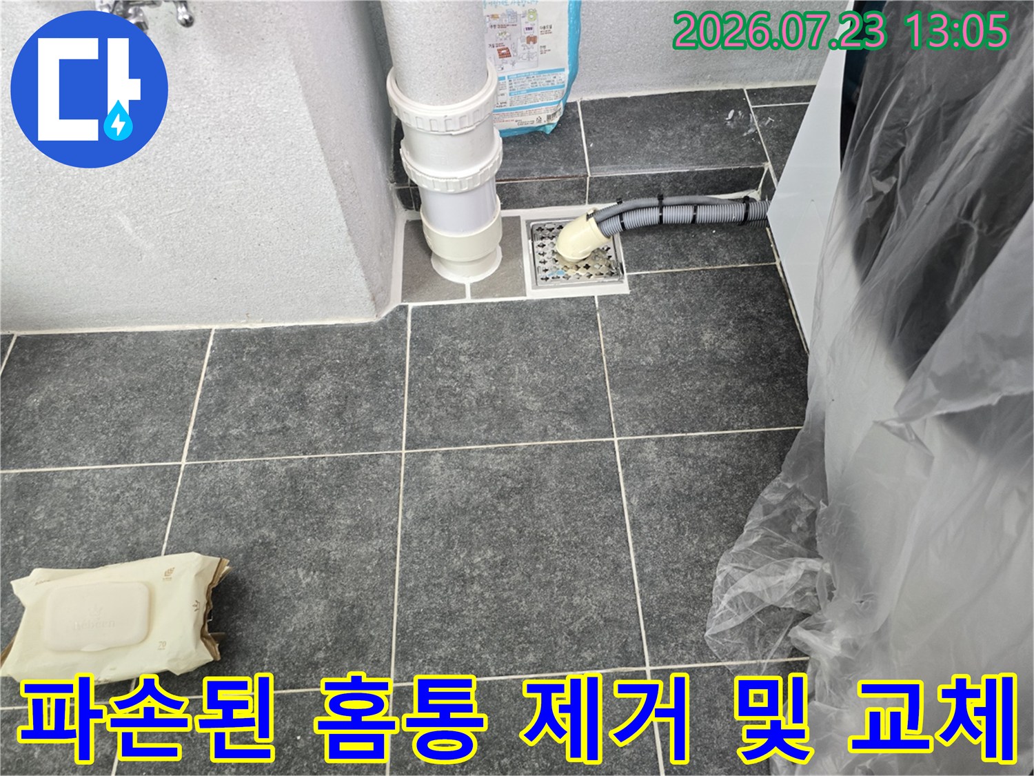 세탁실 바닥의 파손된 배수관 홈통을 철거하고 새 제품으로 연결하는 모습