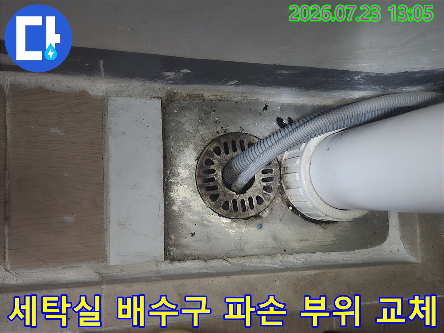 파손된 배수 홈통과 연결 호스가 결합된 상태의 세탁실 바닥 배관부