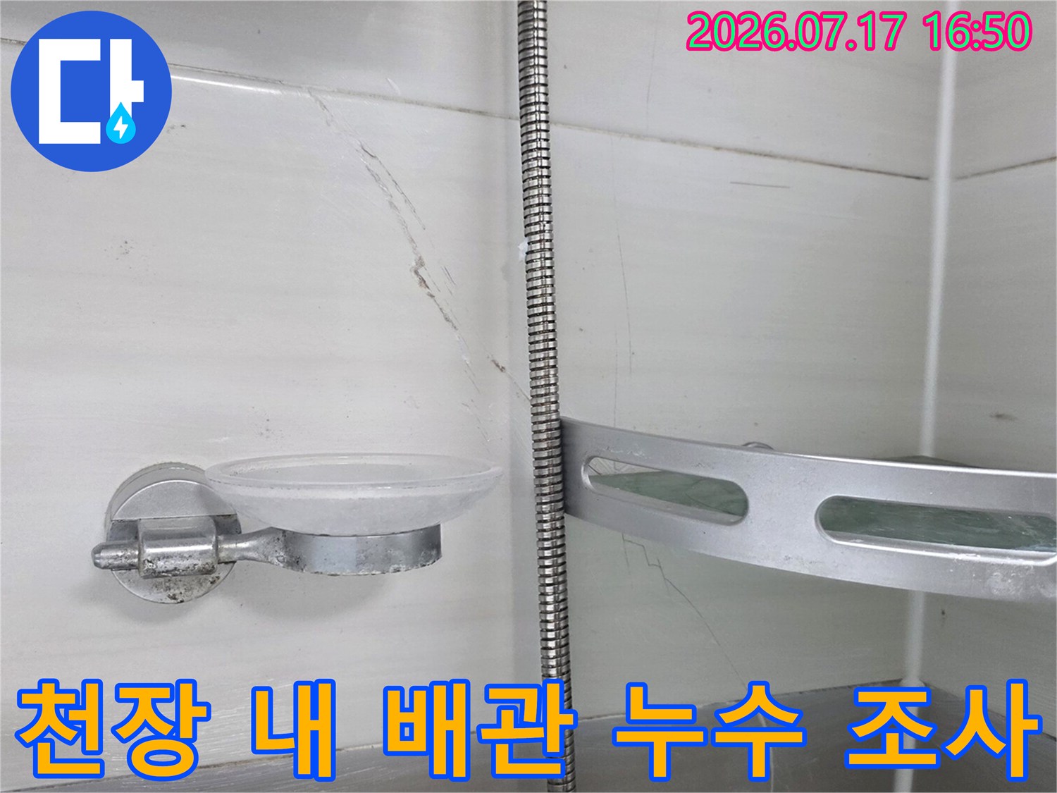 화장실 천장 내부 노출된 금속 배관과 타일 접합부 점검용 사진
