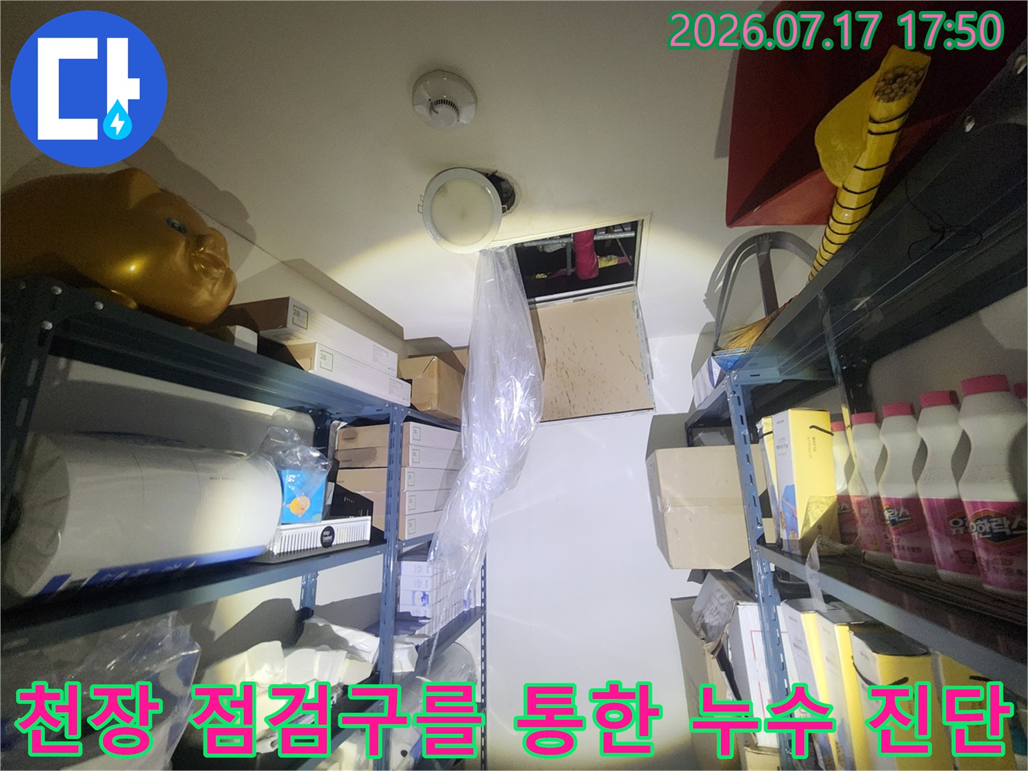 천장의 둥근 구멍과 그 주변으로 배치된 창고 적재물들-누수 현장 사진