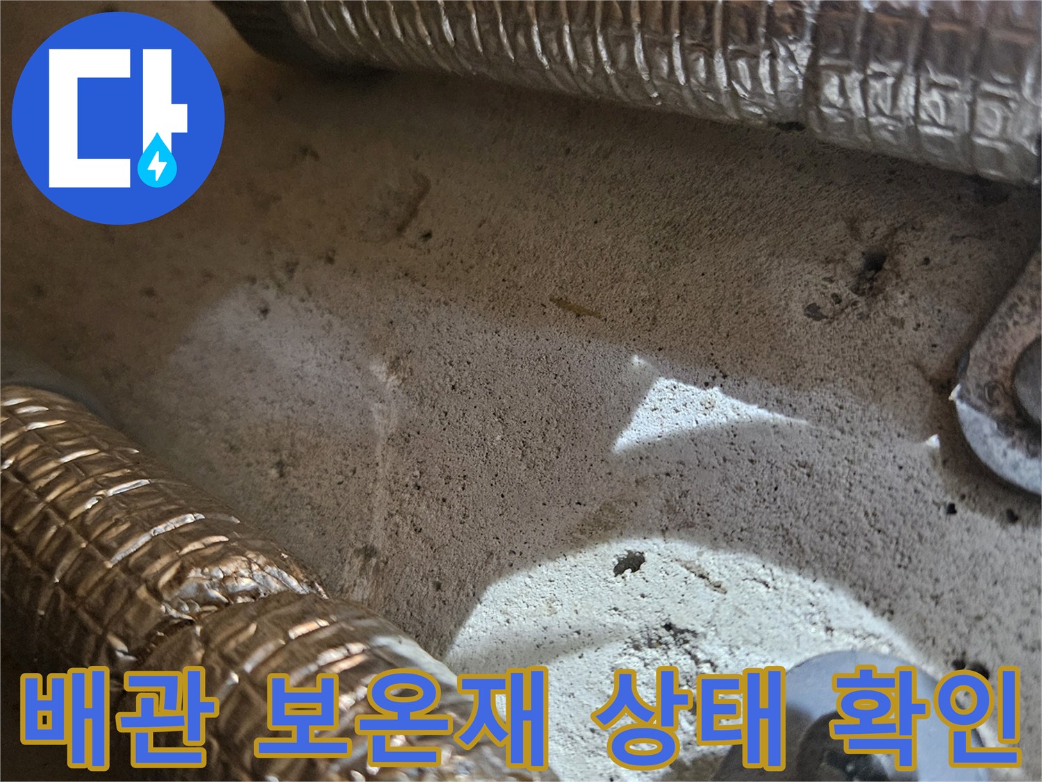보온재로 감싸진 배관의 연결 부위와 고정 장치 근접 사진입니다.