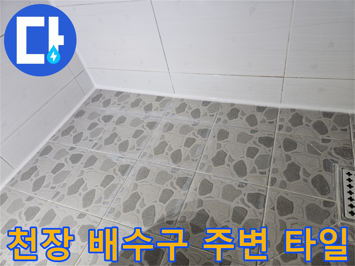 화장실 천장 배수구와 패턴 타일의 근접 촬영본입니다.