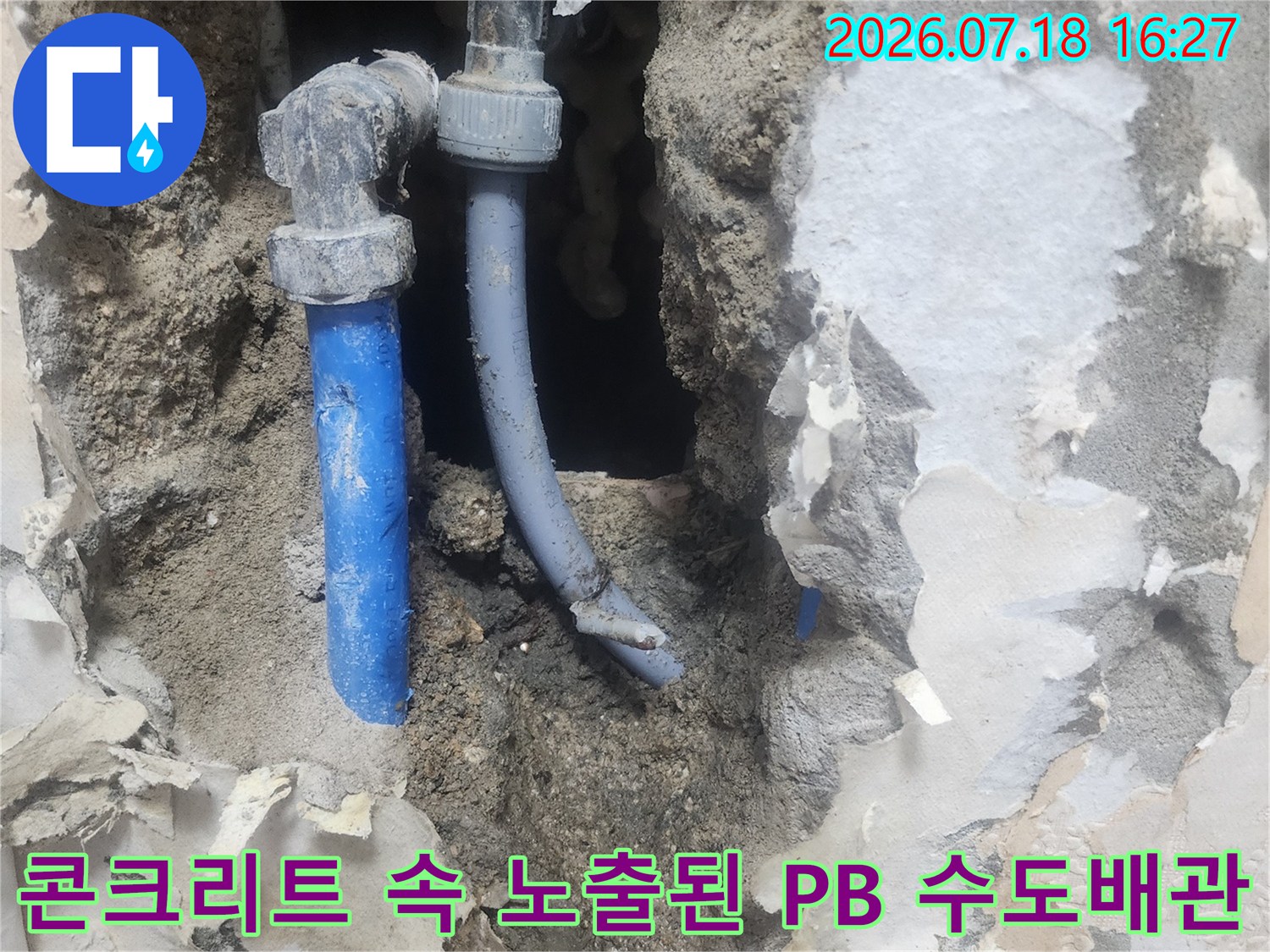 굴착 작업으로 인해 드러난 파란색 플라스틱 배관과 엘보우 연결 부위-누수 수선 직전
