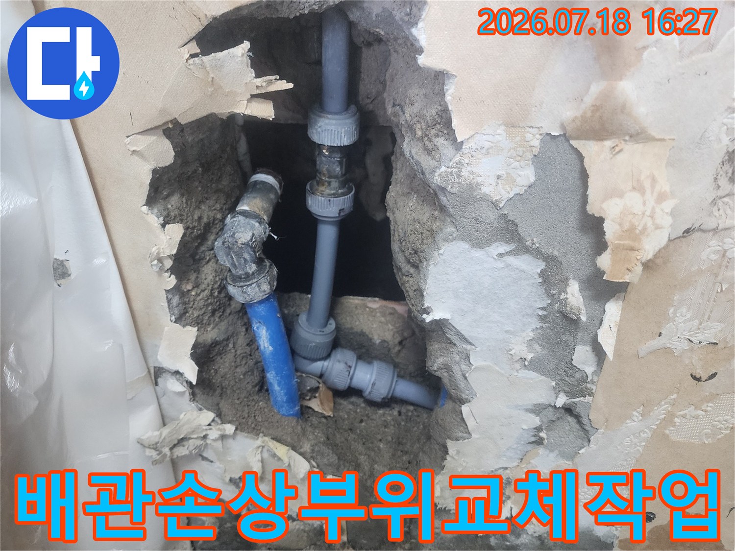 굴착된 회색 콘크리트 구조물 속에 설치된 파란색 수도관-수선 완료 상태