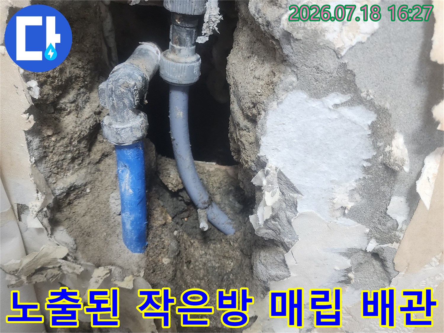 작은방 바닥 콘크리트를 제거하고 드러난 파란색 플라스틱 배관과 회색 연결 부속-누수 지점