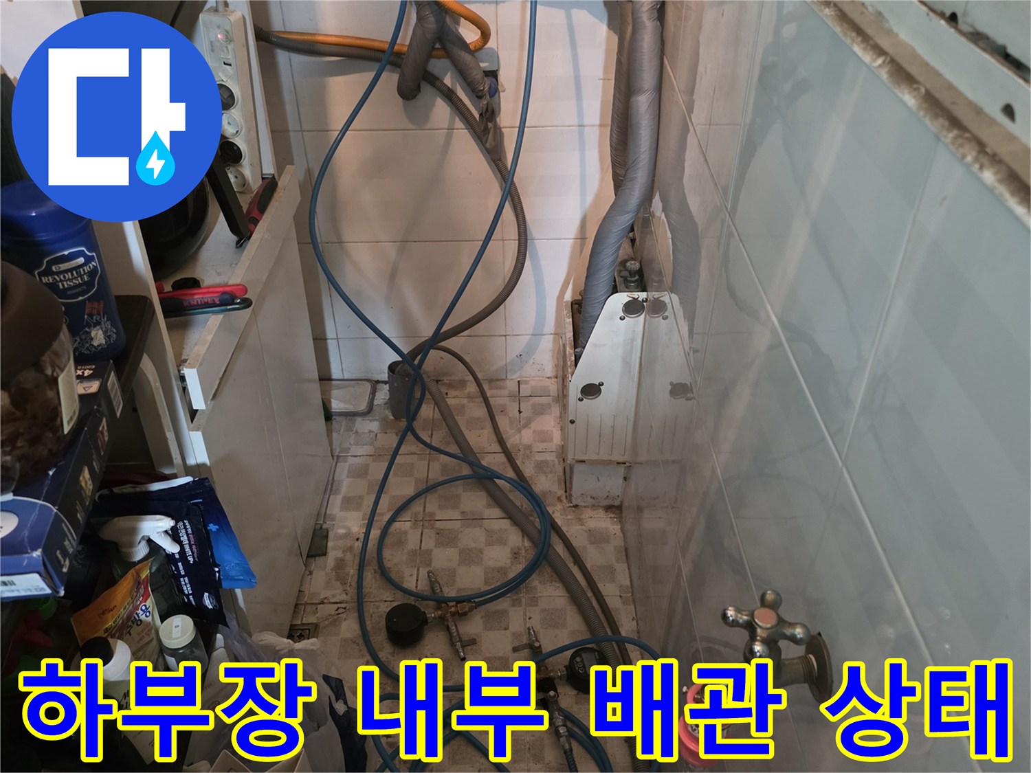 싱크대 밑 수전 연결 밸브와 파란색 호스의 모습