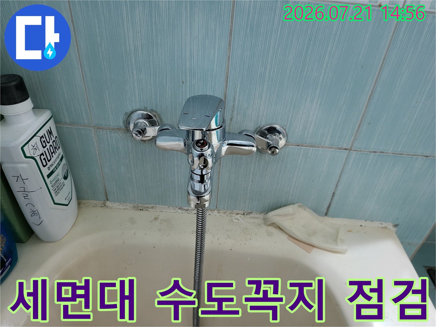 세면대 옆에 설치된 수전과 물때가 묻은 세면대 볼의 모습