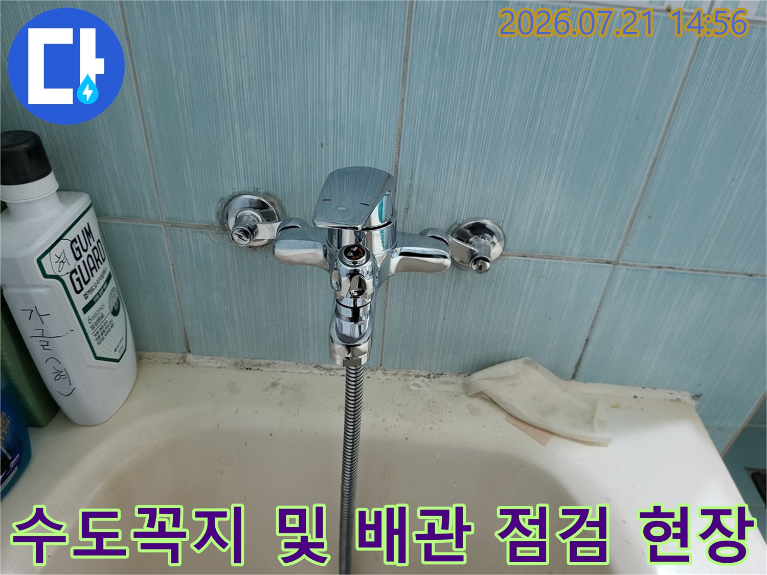 화장실 세면대 상부의 크롬 소재 수도꼭지와 주변 공간 촬영