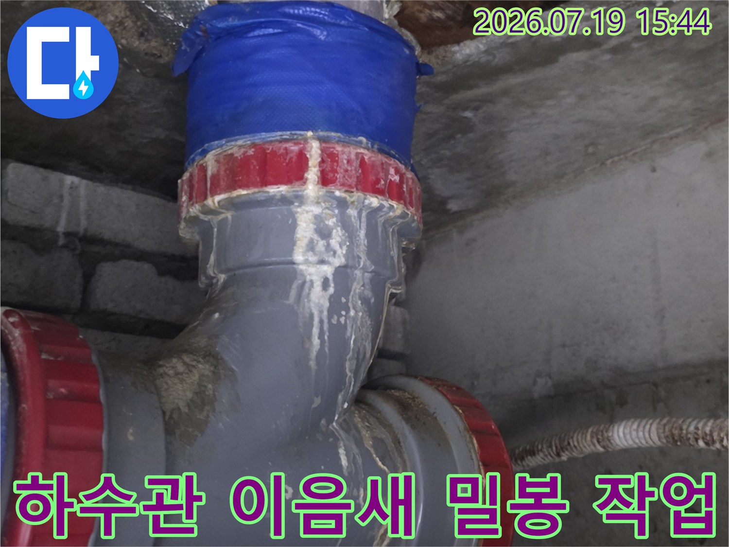 콘크리트 벽면과 연결된 천장 배관의 접합부에 파란색 테이핑 처리가 된 모습