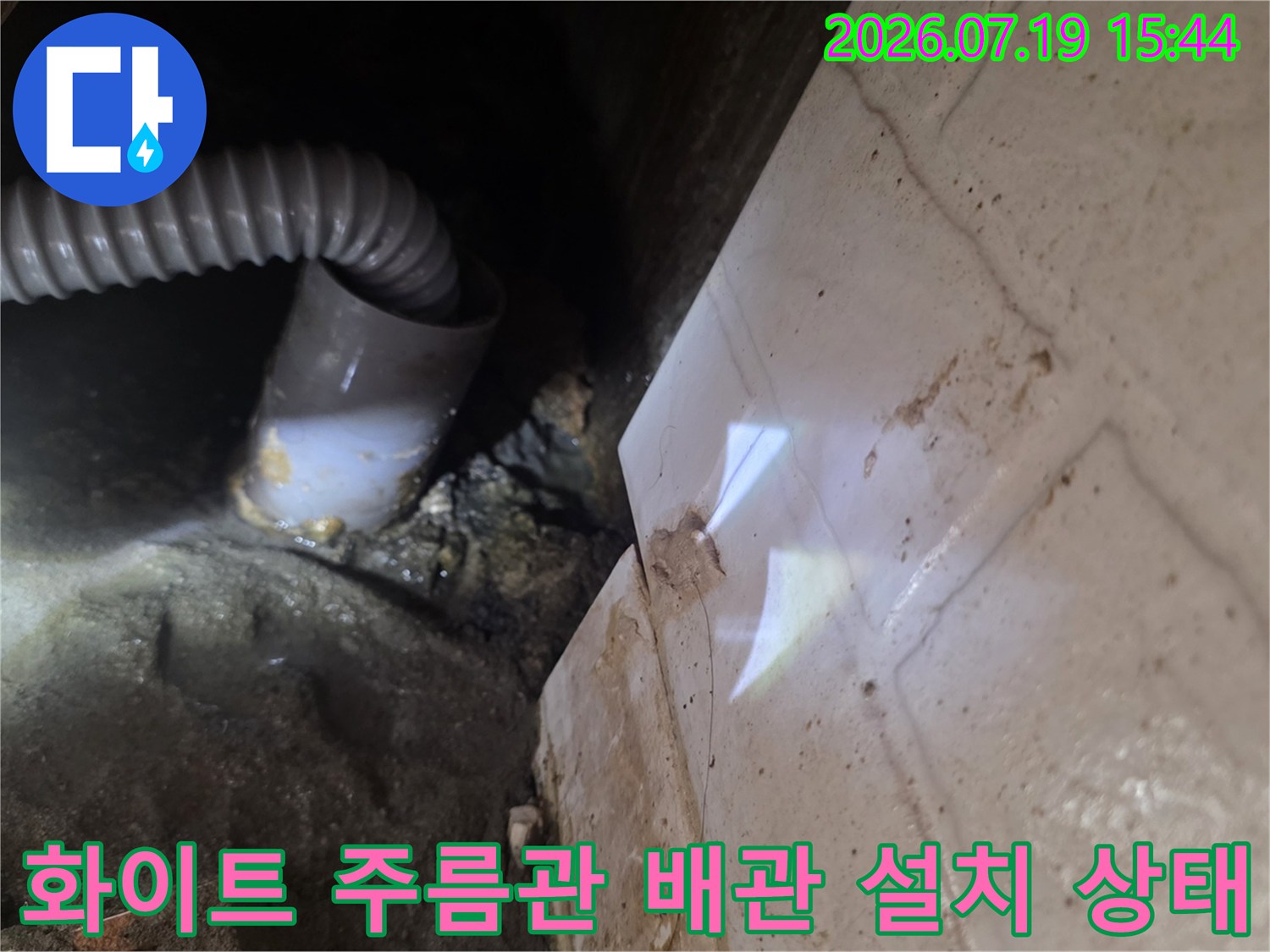 콘크리트 천장 구조물에 연결되어 구부러져 있는 플라스틱 주름관 배관