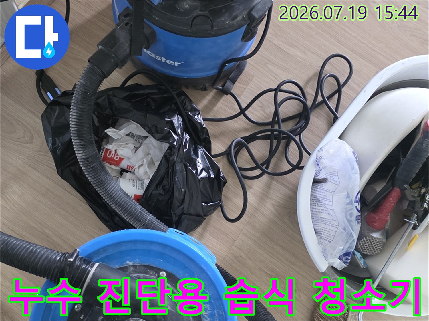 파란색 강력 흡입 장비와 호스-정리함이 놓여 있는 누수 공사 준비 현장