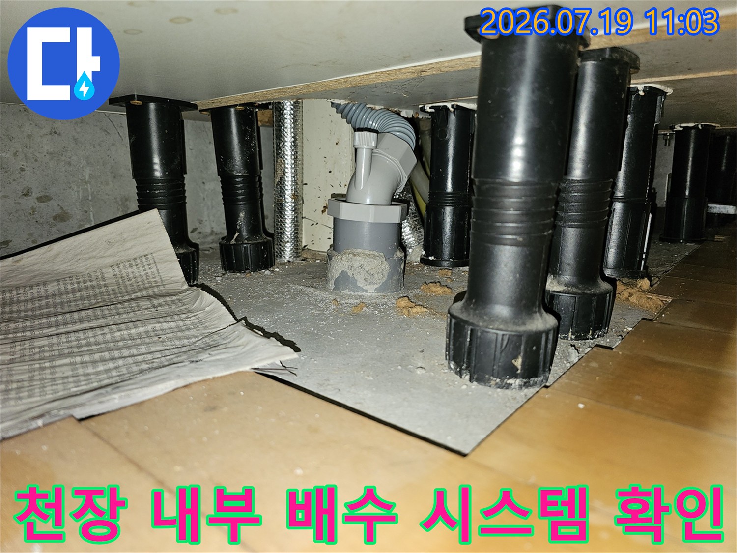회색의-드레인 배관과-검은색 지지 구조물이 설치된 천장 내부