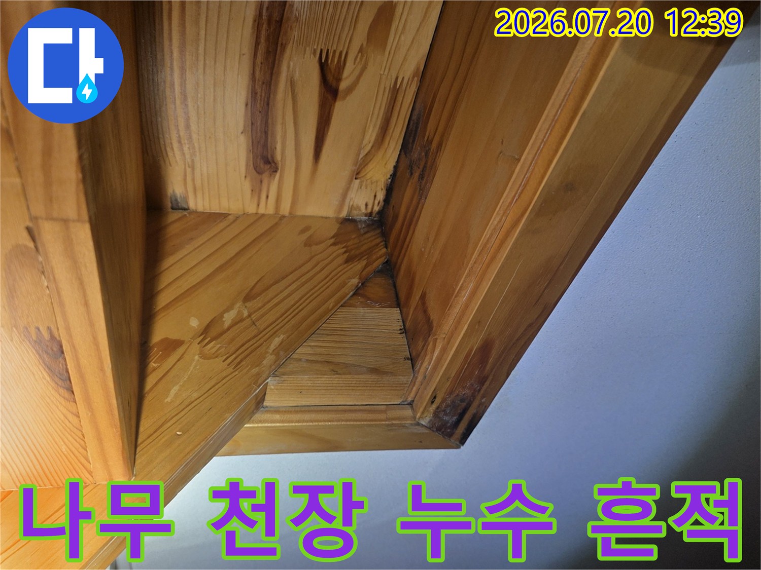 목재로 마감된 천장 구석 부분에 물기가 스며들어 검게 변색된 모습