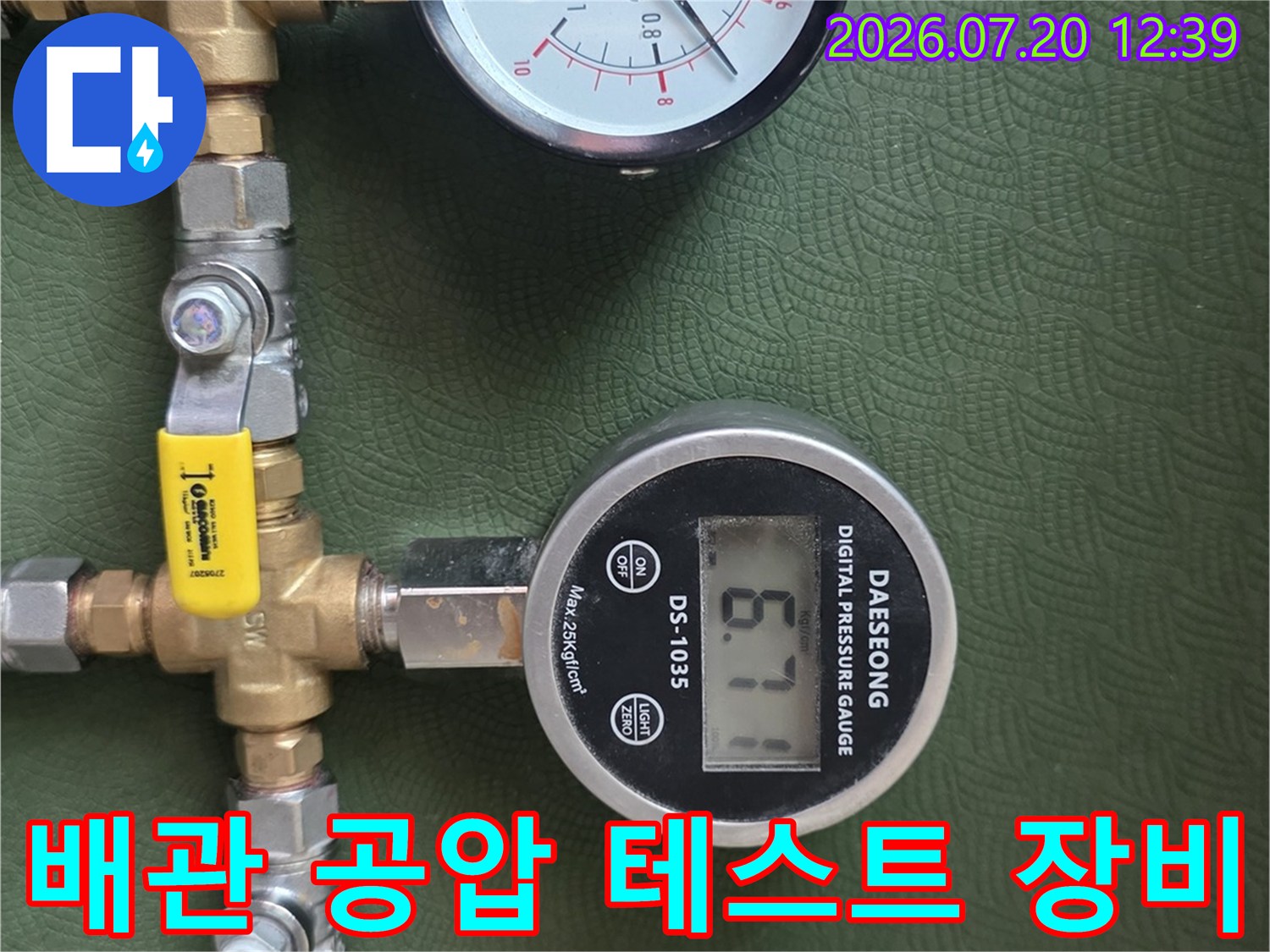 투명 호스와 금속 밸브 그리고 두 개의 압력 측정기가 연결된 모습