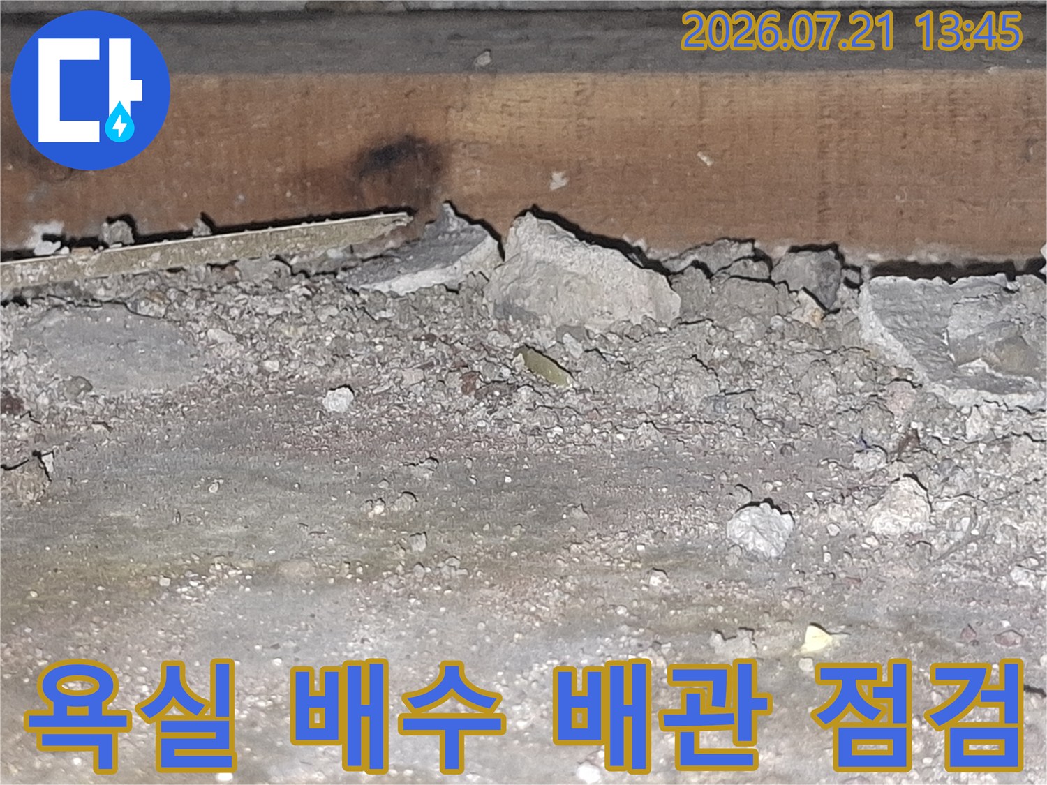 파헤친 바닥 속의 노출된 배수관과 콘크리트 구조물 상태