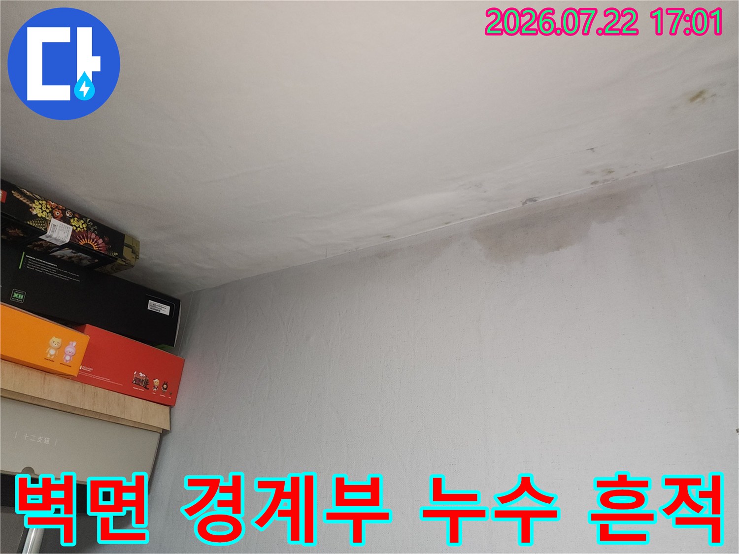 거실 천장 모서리 부분에 짙게 남은 수분 침투의 증거
