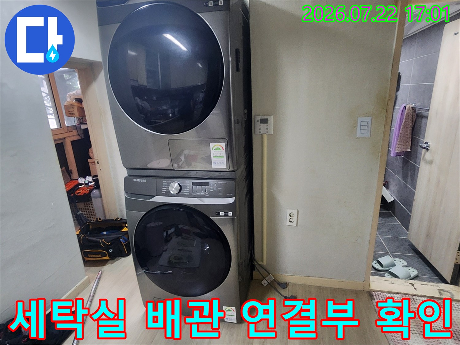 세탁기 옆에 위치한 두 개의 세탁기 및 관련 배관 시설물