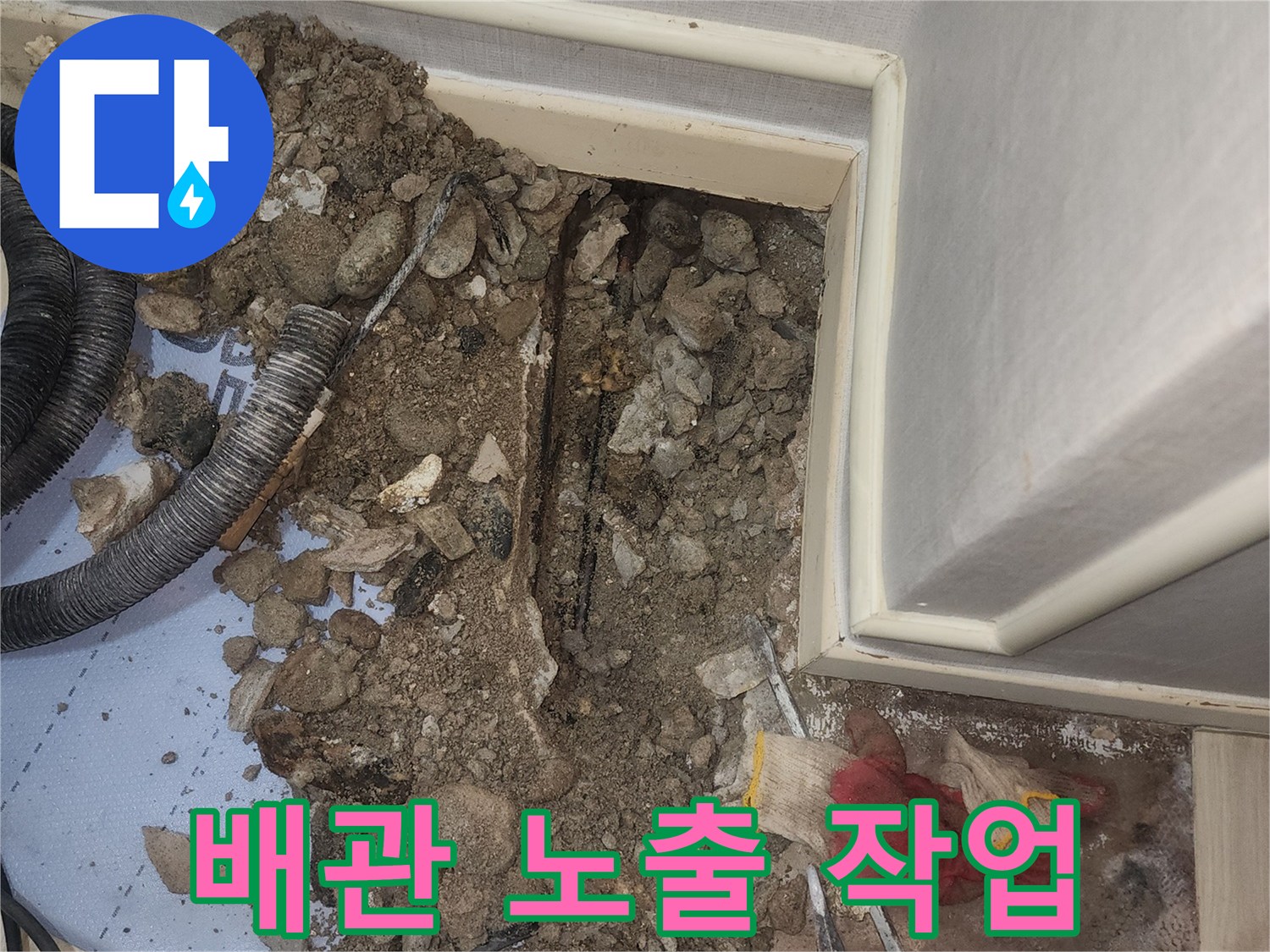 콘크리트 아래 드러난 누수 의심 배관과 주변 자재