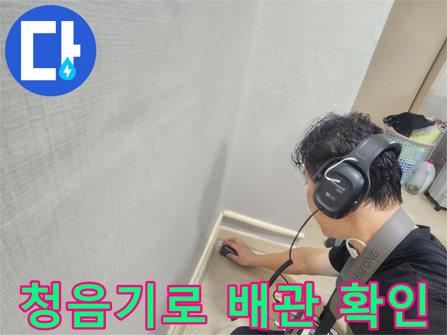 헤드폰을 착용한 엔지니어가 청음식 탐지기를 사용하여 바닥 배관의 미세한 소리를 추적하고 있습니다.