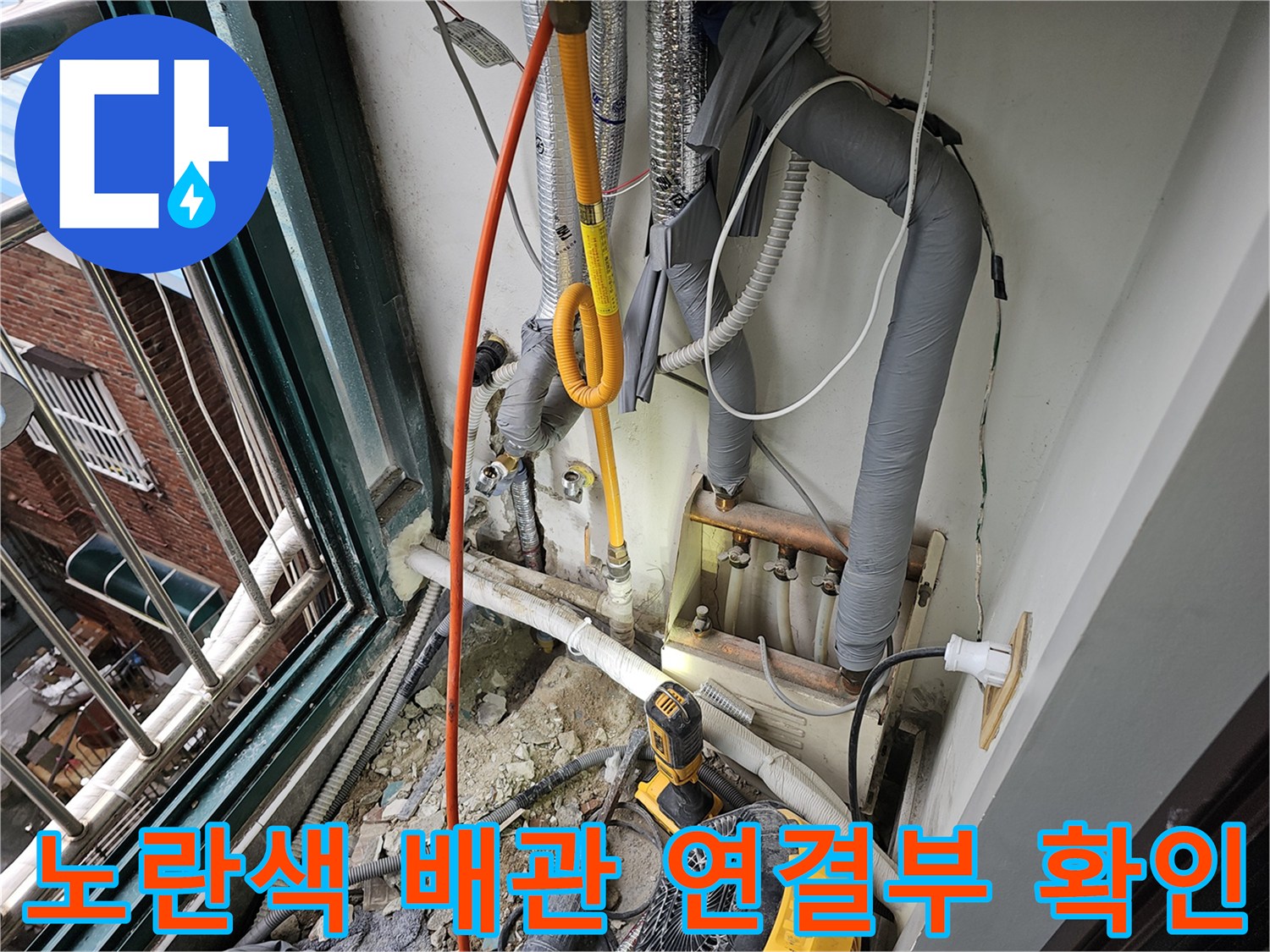 굴착된 벽면 내부의 노란색 급수 배관과 주변 부속을 점검하는 모습입니다.