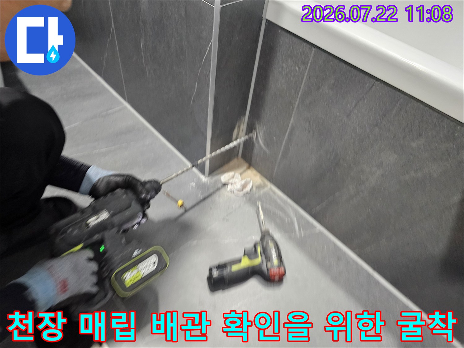 누수 지점을 특정하여 천장 콘크리트 부위를 전동 공구로 정밀하게 파내고 있는 엔지니어의 모습