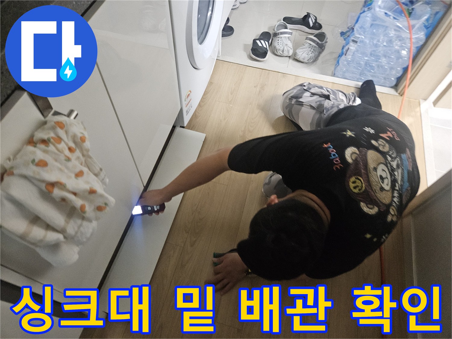 손전등-빛을-이용해-싱크대-아래쪽-배관의-습기를-찾는-장면