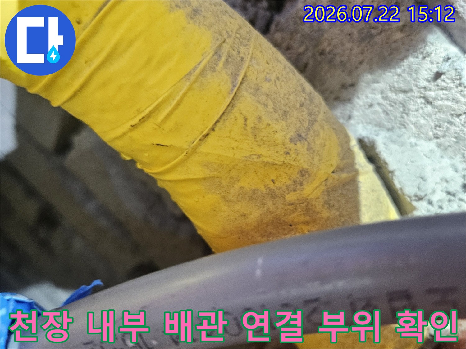 제조 정보가 인쇄된 회색 배관과 노란색 마감재가 씌워진 배관의 근접 사진