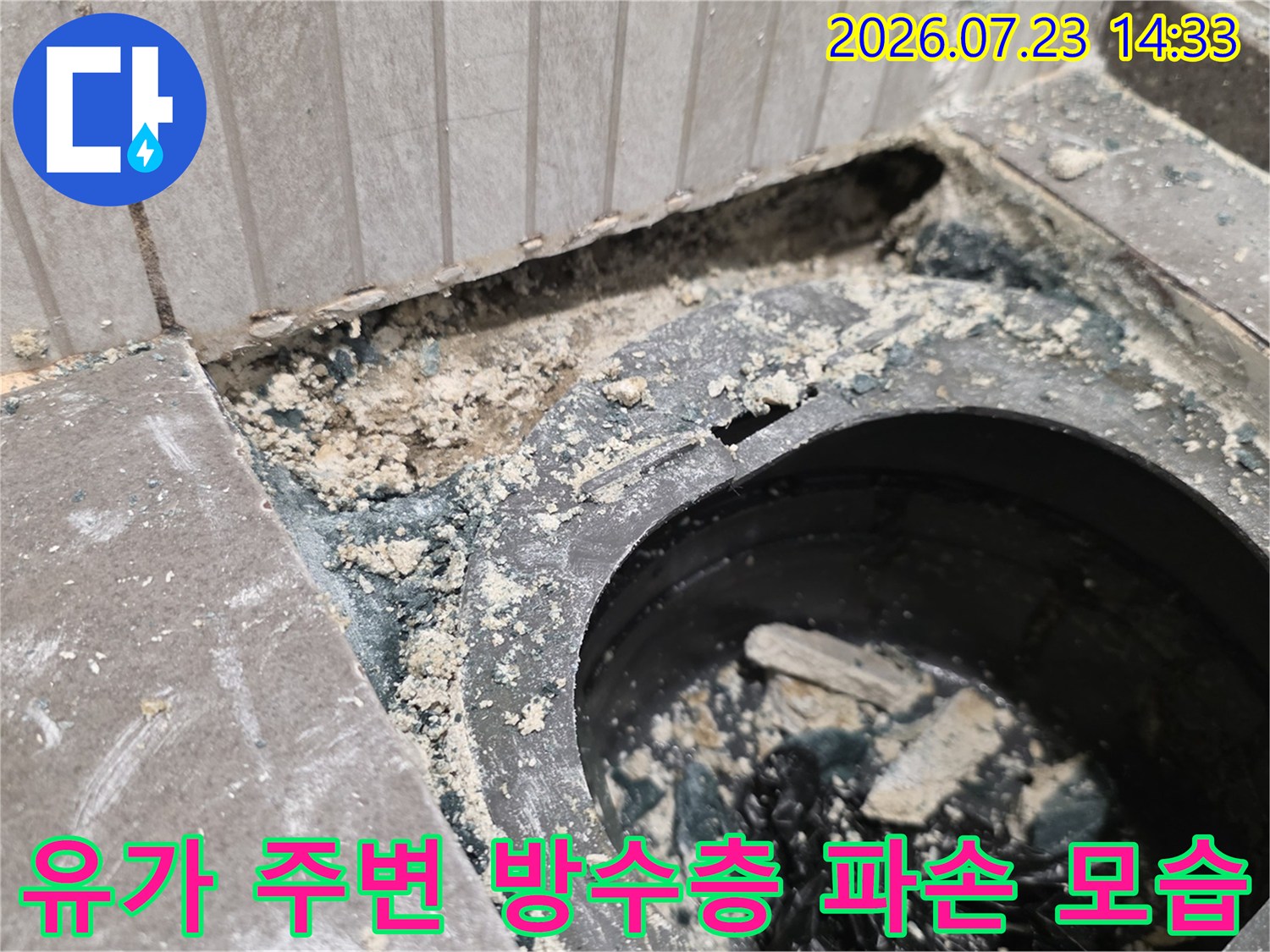 배수구 입구 주변에 시멘트 가루와 오염물이 섞여 있는 누수 지점 사진