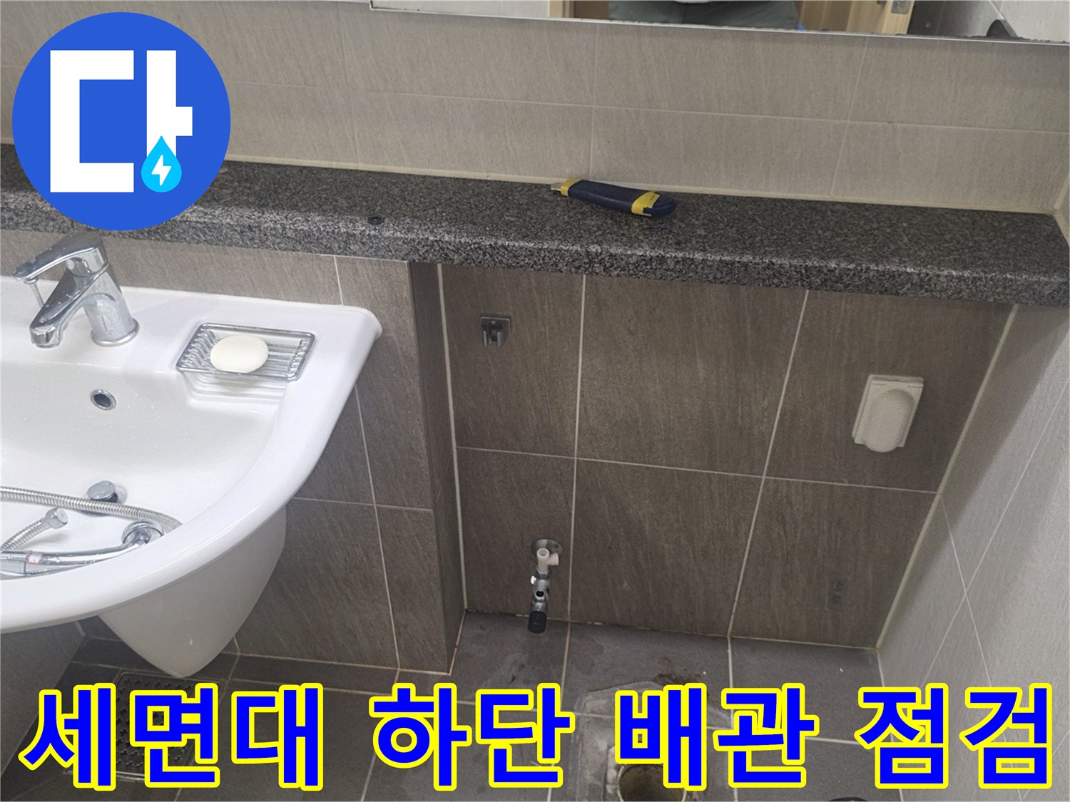 욕실 세면대 아래 배수구와 타일 접합부 근접 촬영