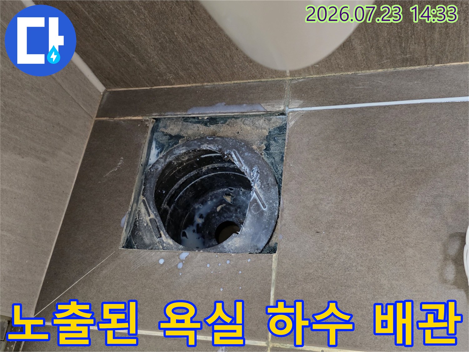 타일 아래에 매립되어 있던 검은색 하수구 배관-주변 시멘트층 노출 상태
