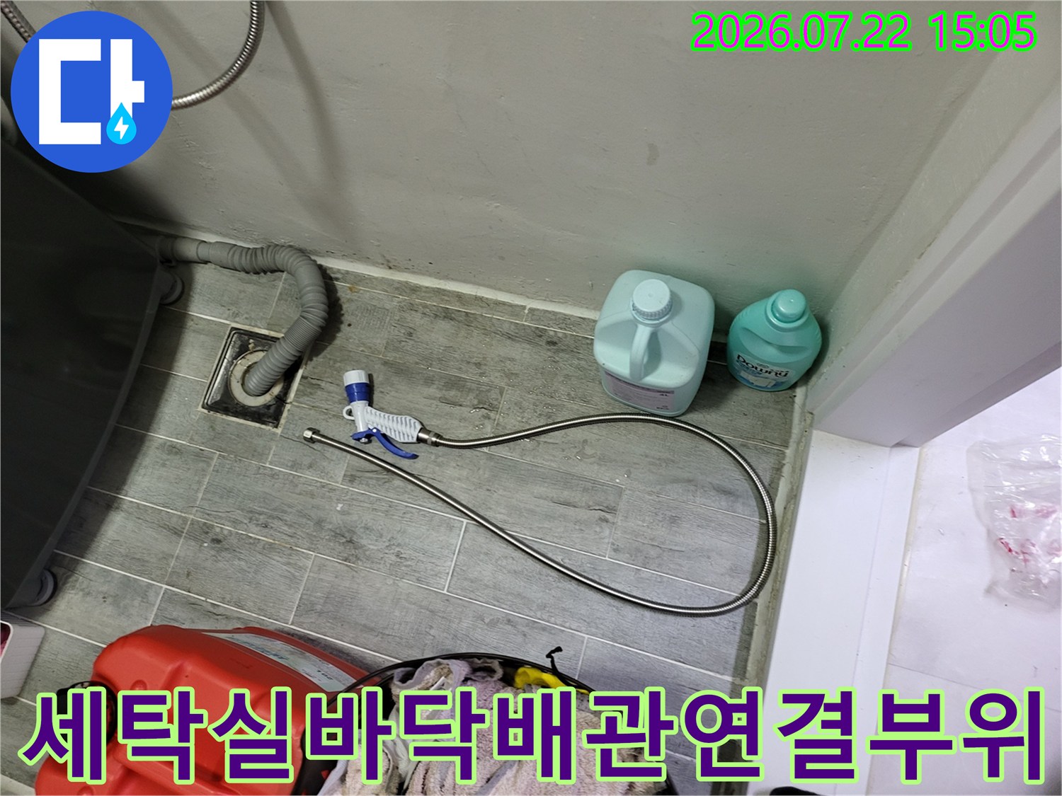 물청소용 분무기와 세제통이 놓인 보일러실 바닥의 배수관 모습