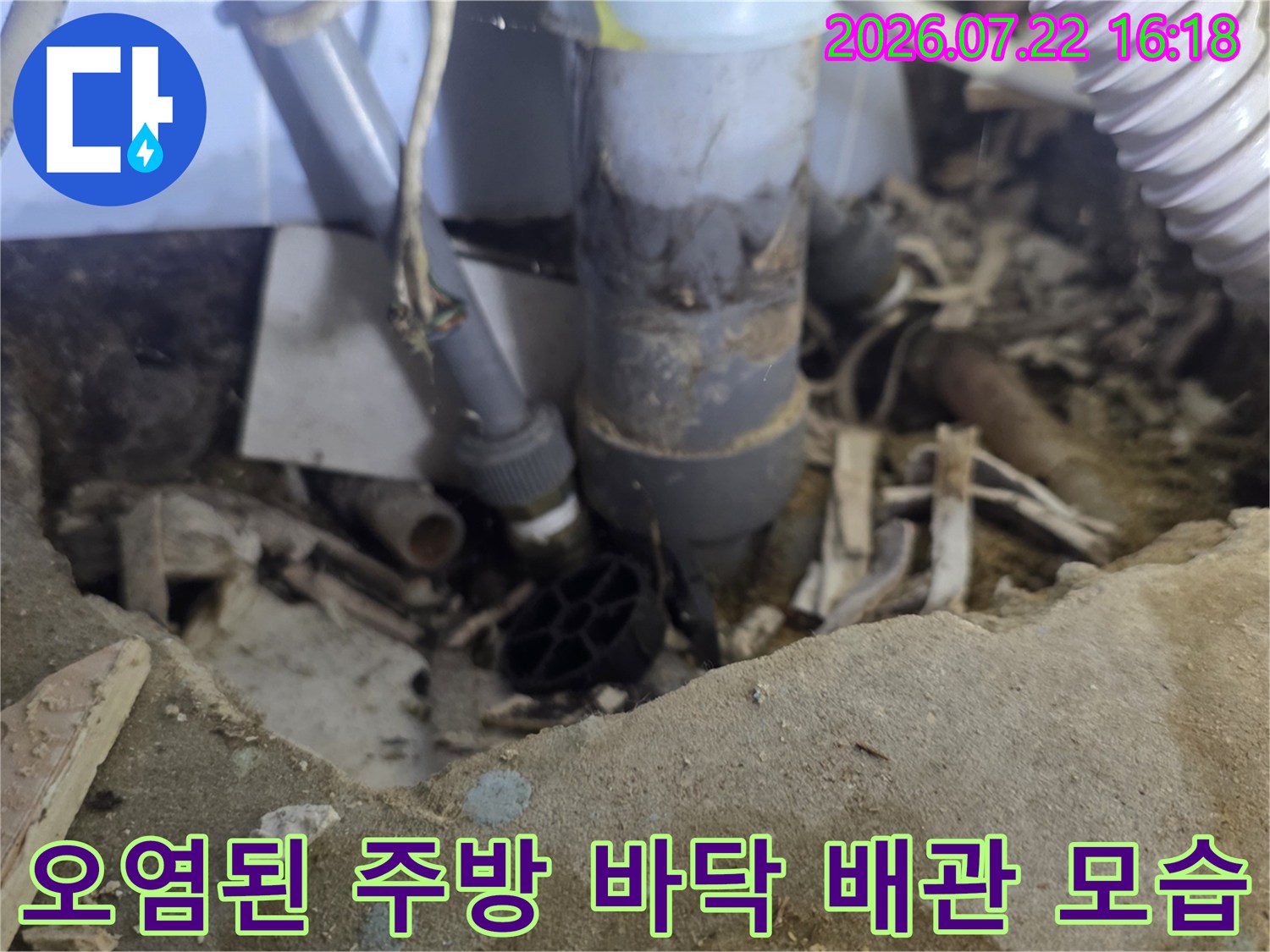 습기로 인해 변색된 싱크대 하단 바닥과 복잡하게 얽힌 배관 연결부-누수 진단 사진