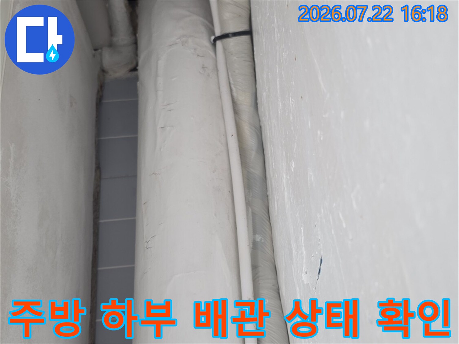 싱크대 하단에 설치된 흰색 보온재 마감 배관-현장 점검 모습