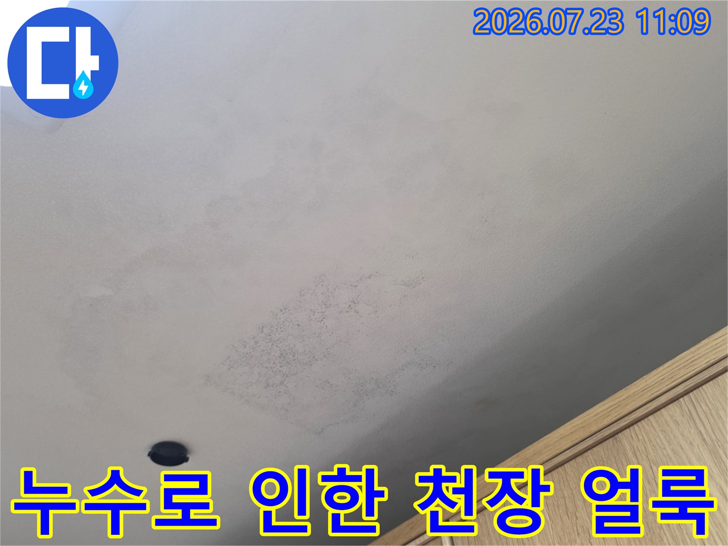 물샘 현상으로 인해 누런색과 회색으로 오염된 주방 천장의 근접 사진