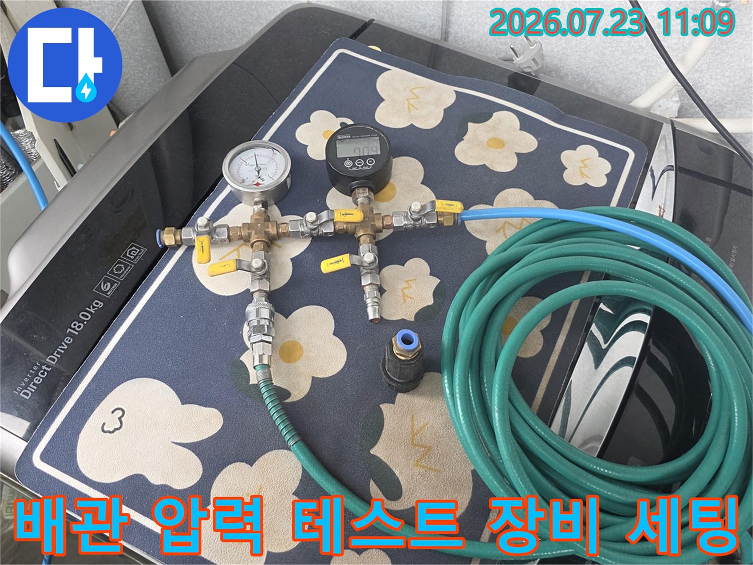 보일러 배관에 연결된 디지털 압력계와 아날로그 게이지-초록색 호스가 연결된 정밀 검사 장비 모습