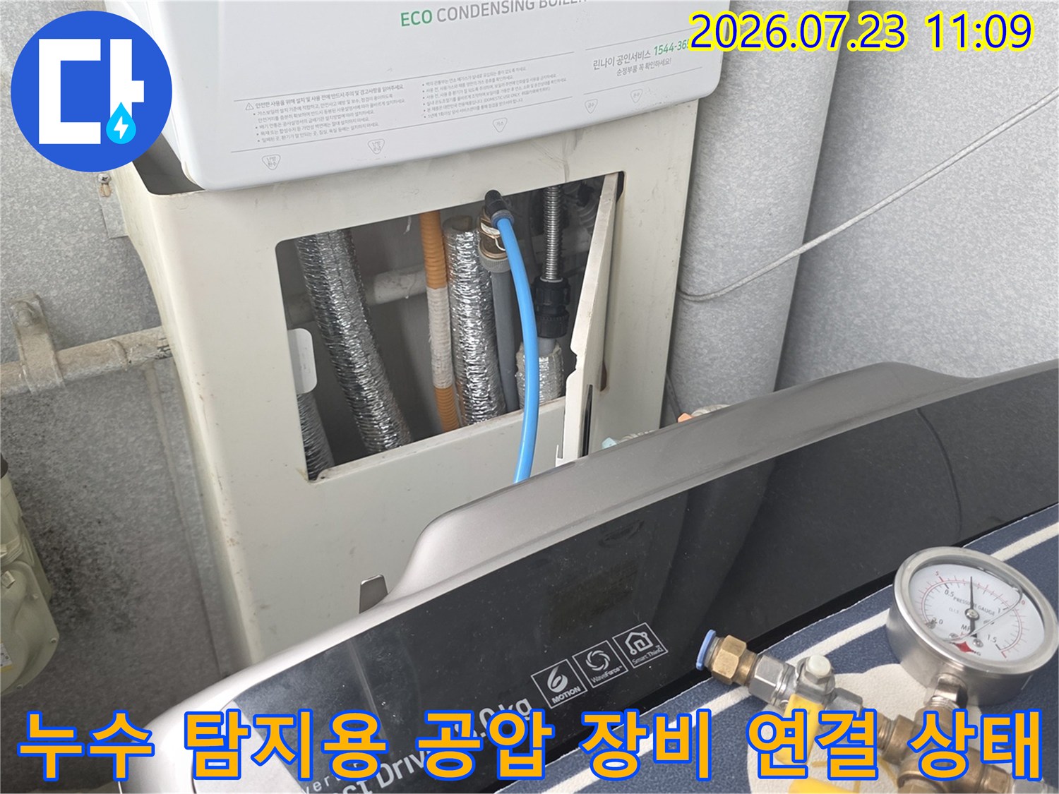 보일러 본체와 배관 사이에 설치된 파란색 연결 호스와 압력 측정기