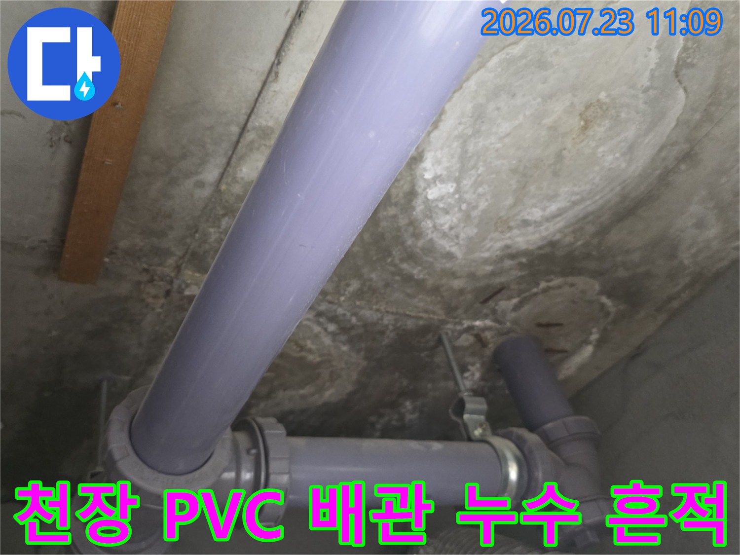 콘크리트 천장에 설치된 보라색 배관 주변의 변색된 습기 자국 사진