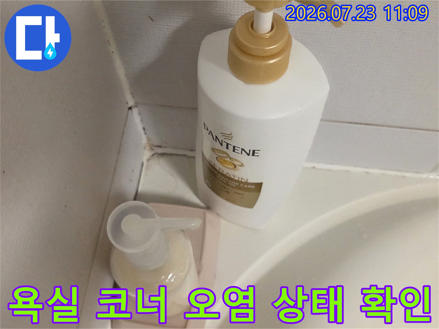 화장실 타일 모서리와 실리콘 부위에 변색과 곰팡이가 발생한 모습