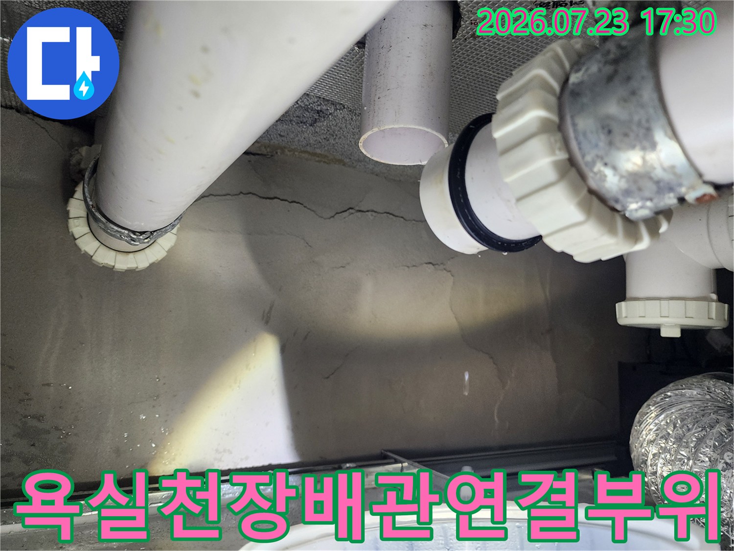 화장실 천장에 설치된 흰색 pvc 하수 배관과 조임 너트 부속의 근접 사진
