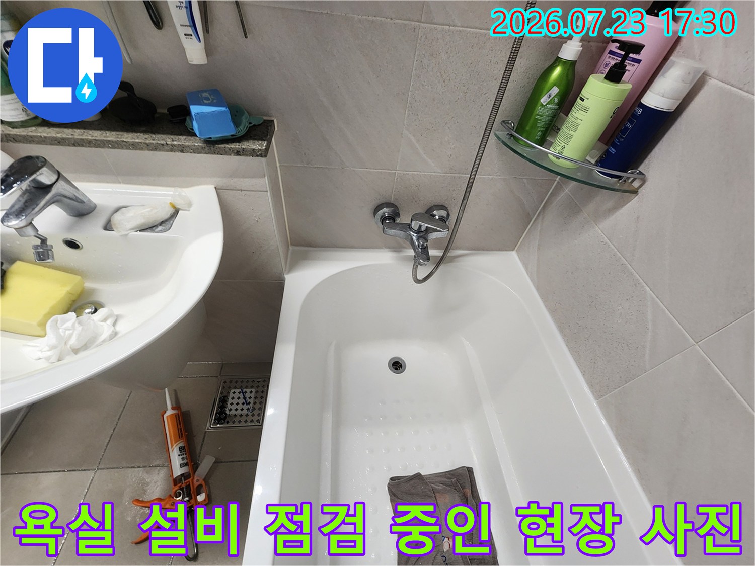 흰색-도기-설비와-바닥에-놓인-주황색-수공구가-함께-찍힌-사진