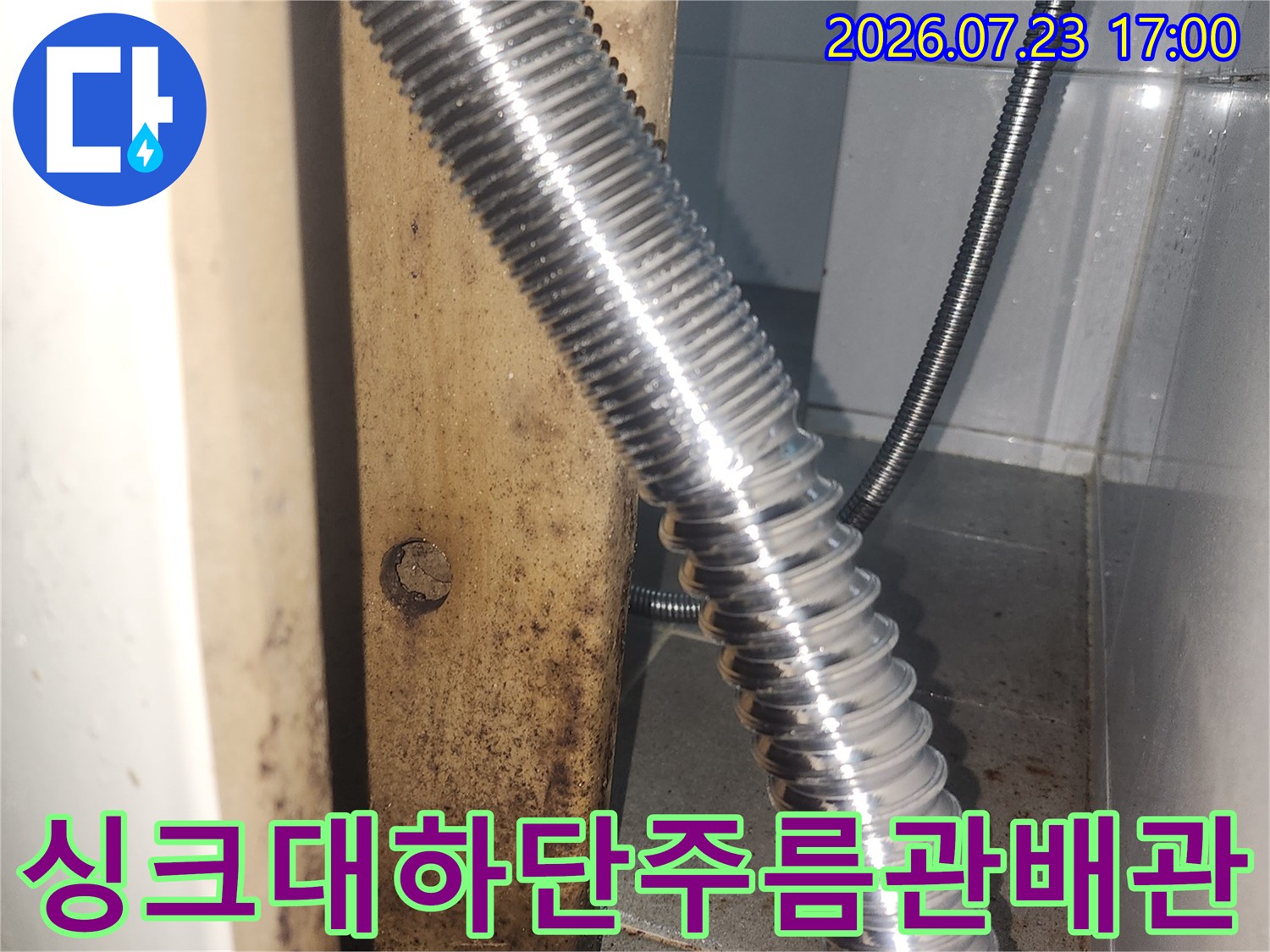 싱크대 아래쪽에 설치된 금속 재질의 주름관 배관 모습-누수 점검 부위