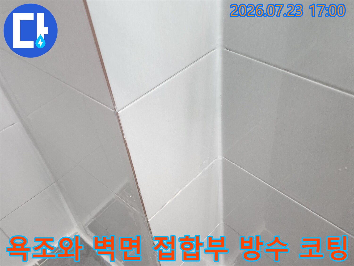 흰색 실리콘을 사용하여-욕조 테두리와 타일 사이의 간격을 밀착 시공한 장면