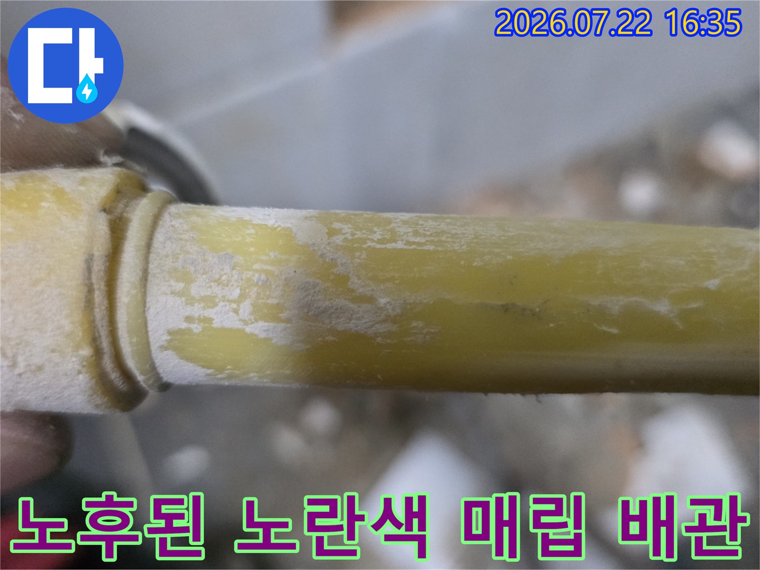 굴착된 벽면 속에서-누수가 발생한 노란색 수도 배관의 근접 사진