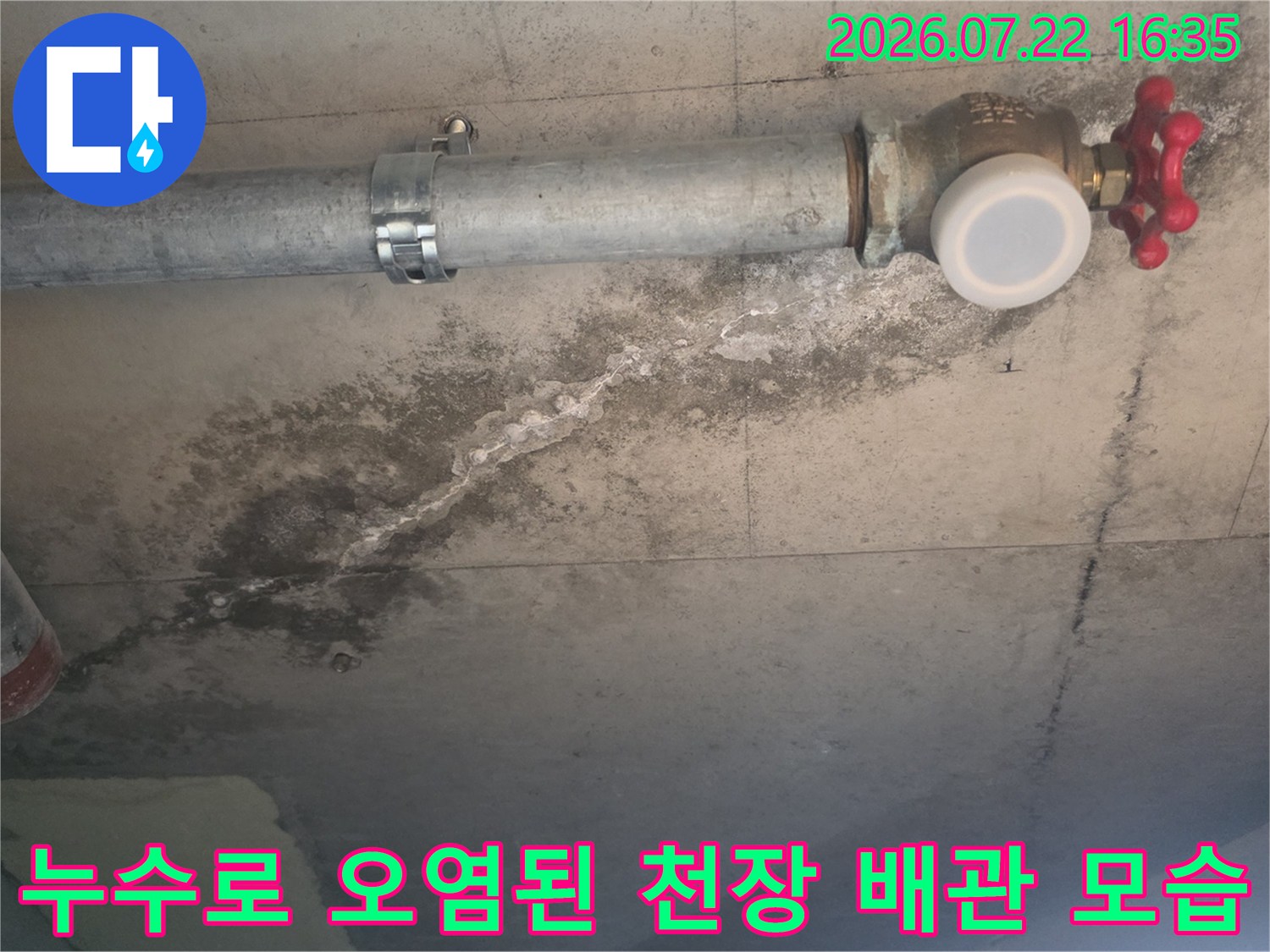 금속 배관과 빨간색 핸들 밸브가 있는 천장의 콘크리트 면에 발생한 누수 자국-사진