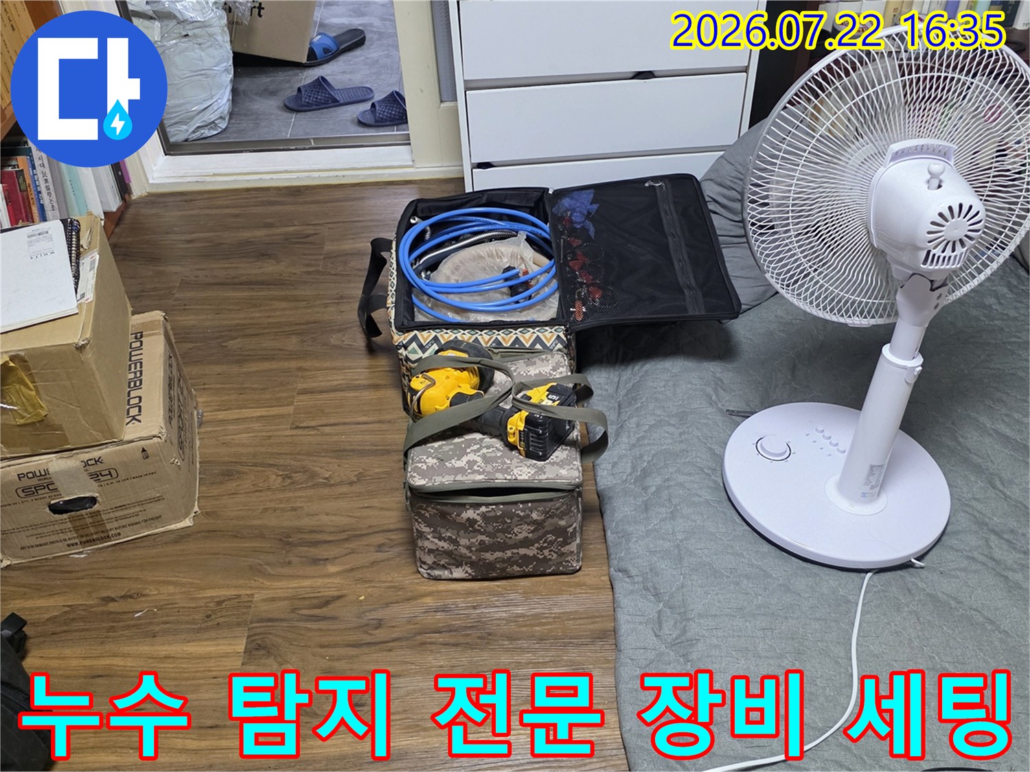 방바닥에 놓인 파란색 호스와 전동공구가 담긴 공구함-누수 탐지를 위한 준비 과정