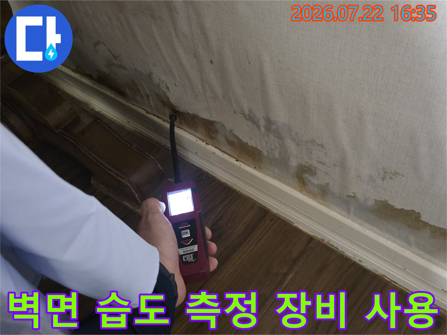 정릉동 현장에서 엔지니어가 누수 탐지기를 사용하여 벽면의 습도를 측정하는 모습
