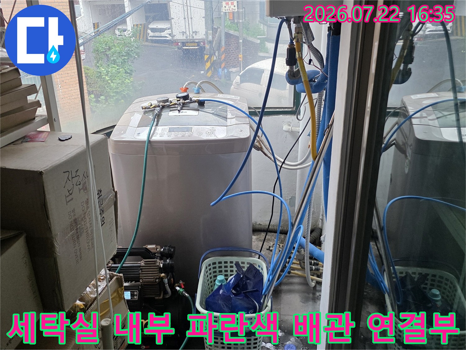 하얀색 세탁기 옆으로 이어지는 파란색 플라스틱 수도 배관-연결 상태 사진